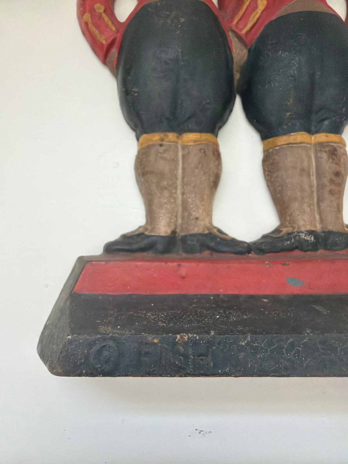 Close-up of the "Fish / 272" maker's mark stamped on the base of the antique Hubley footmen doorstop
